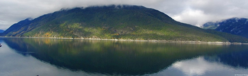 Reflection of island shaped like a fish photo for "Skyhold" poem by Winluck Wong, a writer living in New Brunswick